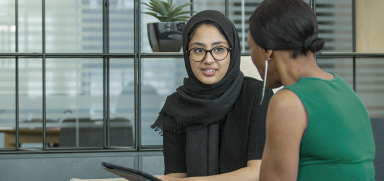 Two women sitting talking in a meeting room