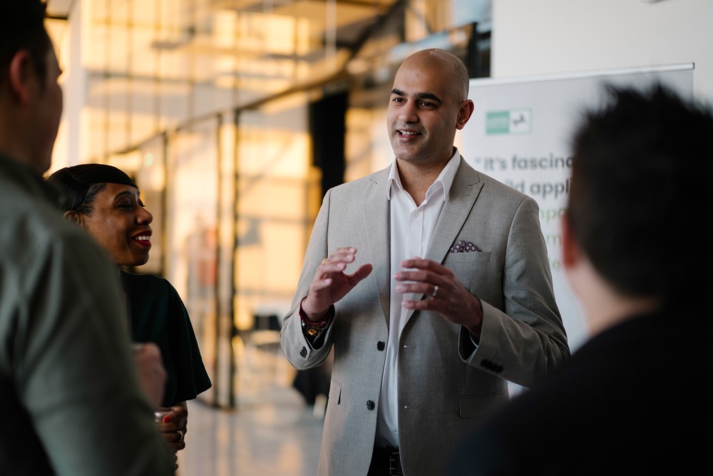 Rax presenting to a small group of people gathered round a display board