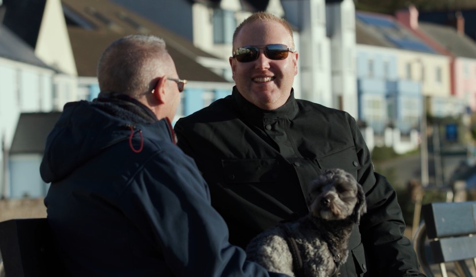 Ryan and his husband with their dog on the beach