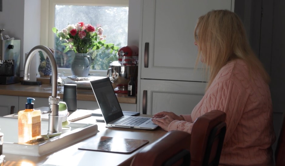 Theresa working on her laptop at the kitchen table