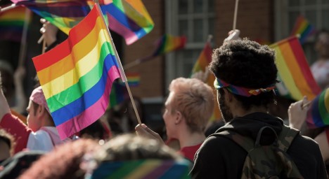 Rainbow flags being waved at a Pride march