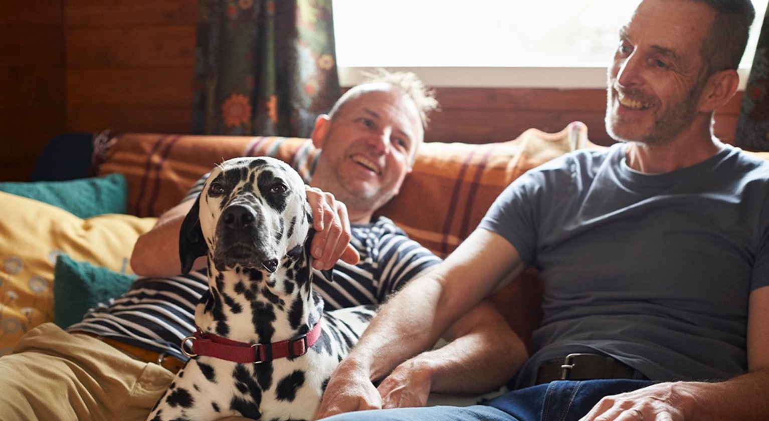 Two people sitting with a dalmatian