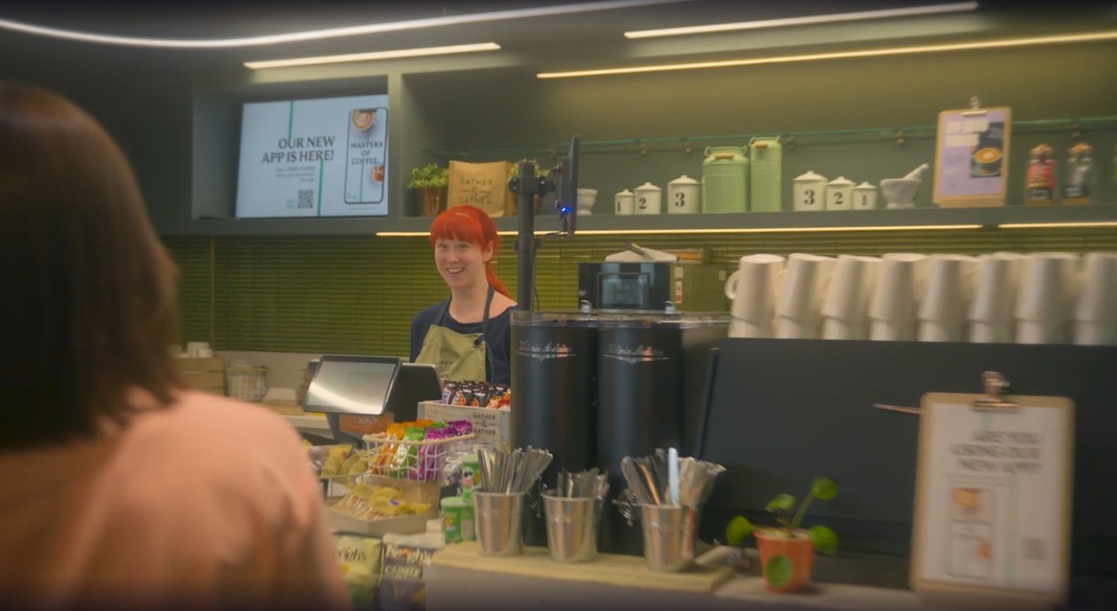 Lady smiling at someone behind the counter of the cafe