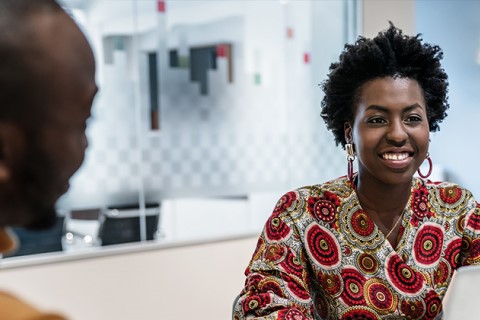 Black women in meeting room chatting with others