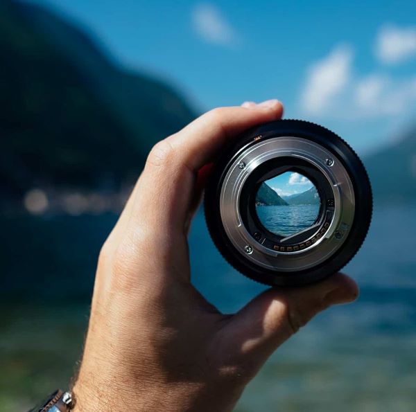 A hand holding a camera lense