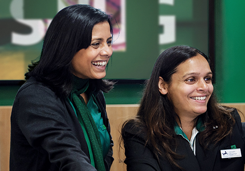 two female branch employees serving customers 