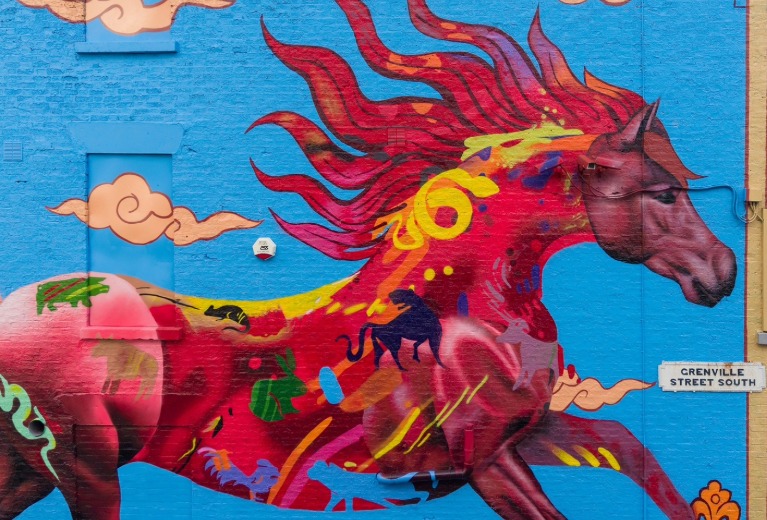 Colourful mural of a flowing red horse painted on a bright blue wall on Grenville Street South, Liverpool, blending Chinese symbols and myth-inspired imagery.