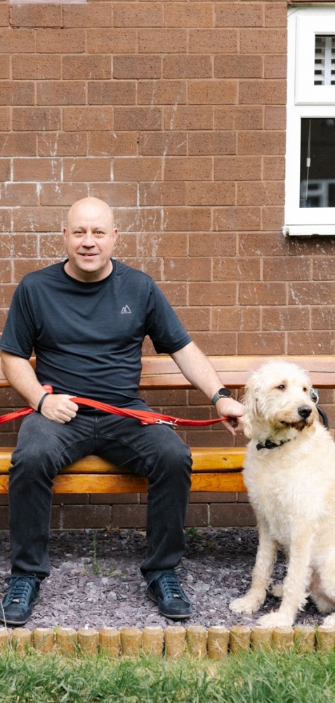 Ray sits with his guide dog, Garçon.