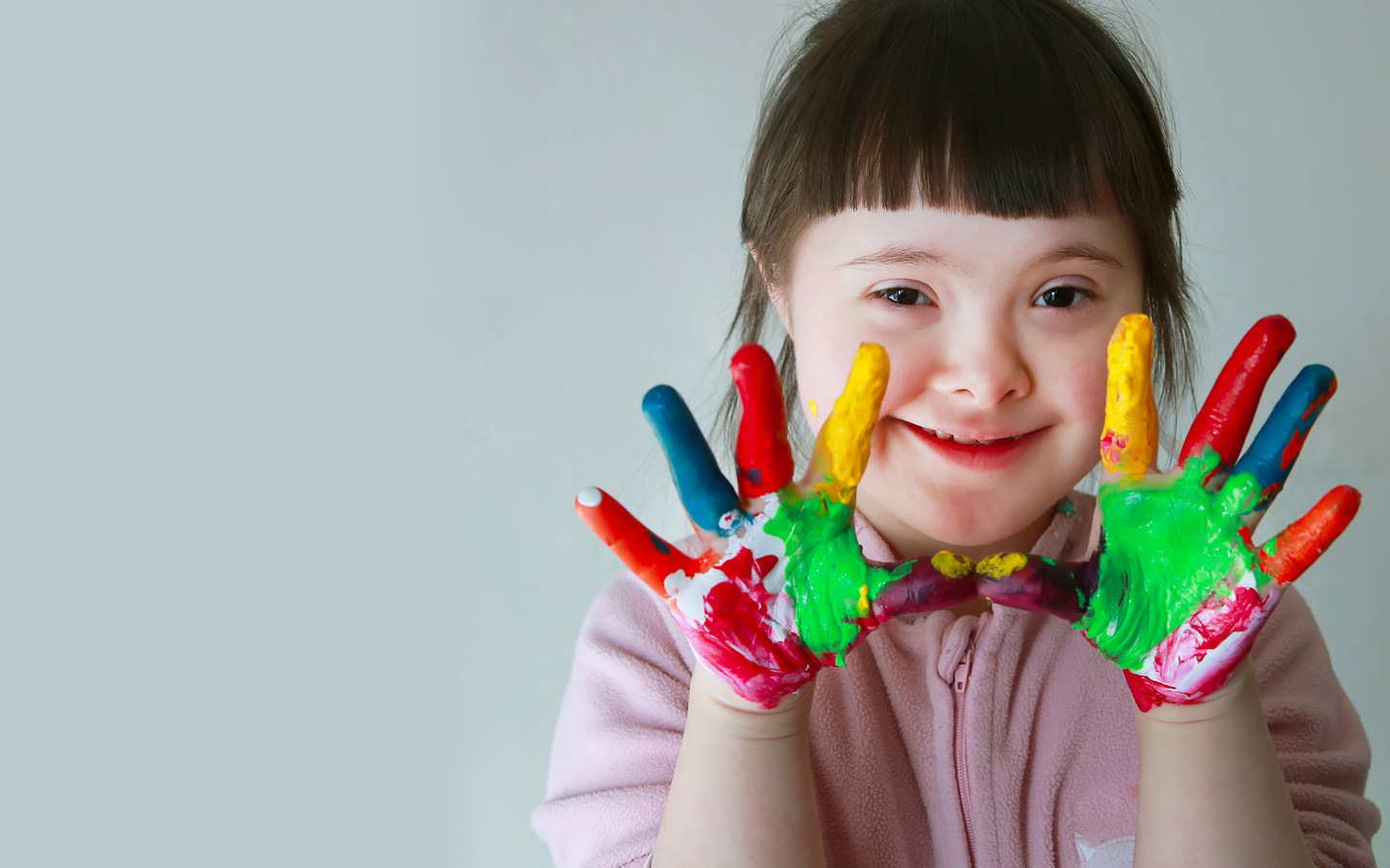 Young girl with Down Syndrome finger painting
