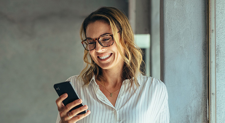 Woman smiling at mobile phone