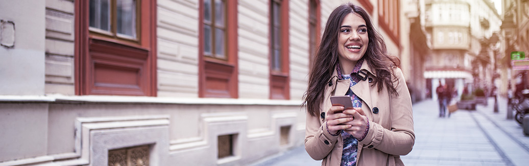 Woman holding mobile phone and smiling